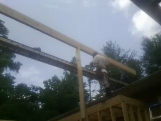 Carpenter setting a ridge beam over a new addition frame — Ice Dam Removal by Roofing Brothers in Twin Mountain