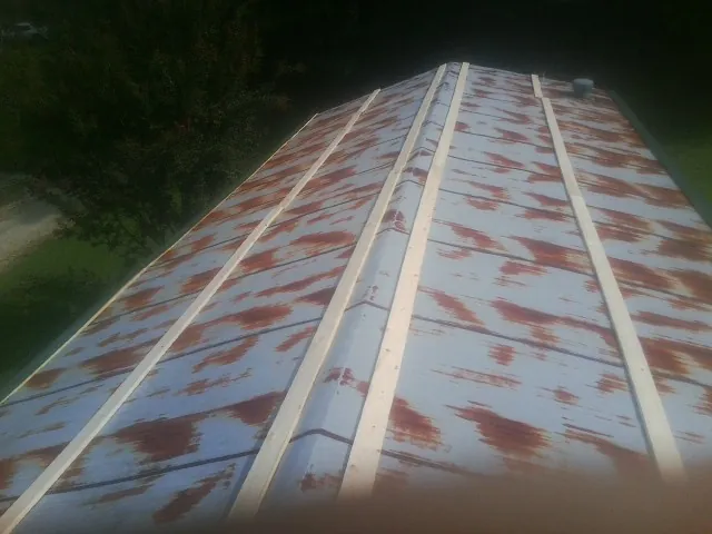Rusted metal roof panels with new wood purlins before replacement — Storm Damage Roof Repair in Twin Mountain by Roofing Brothers