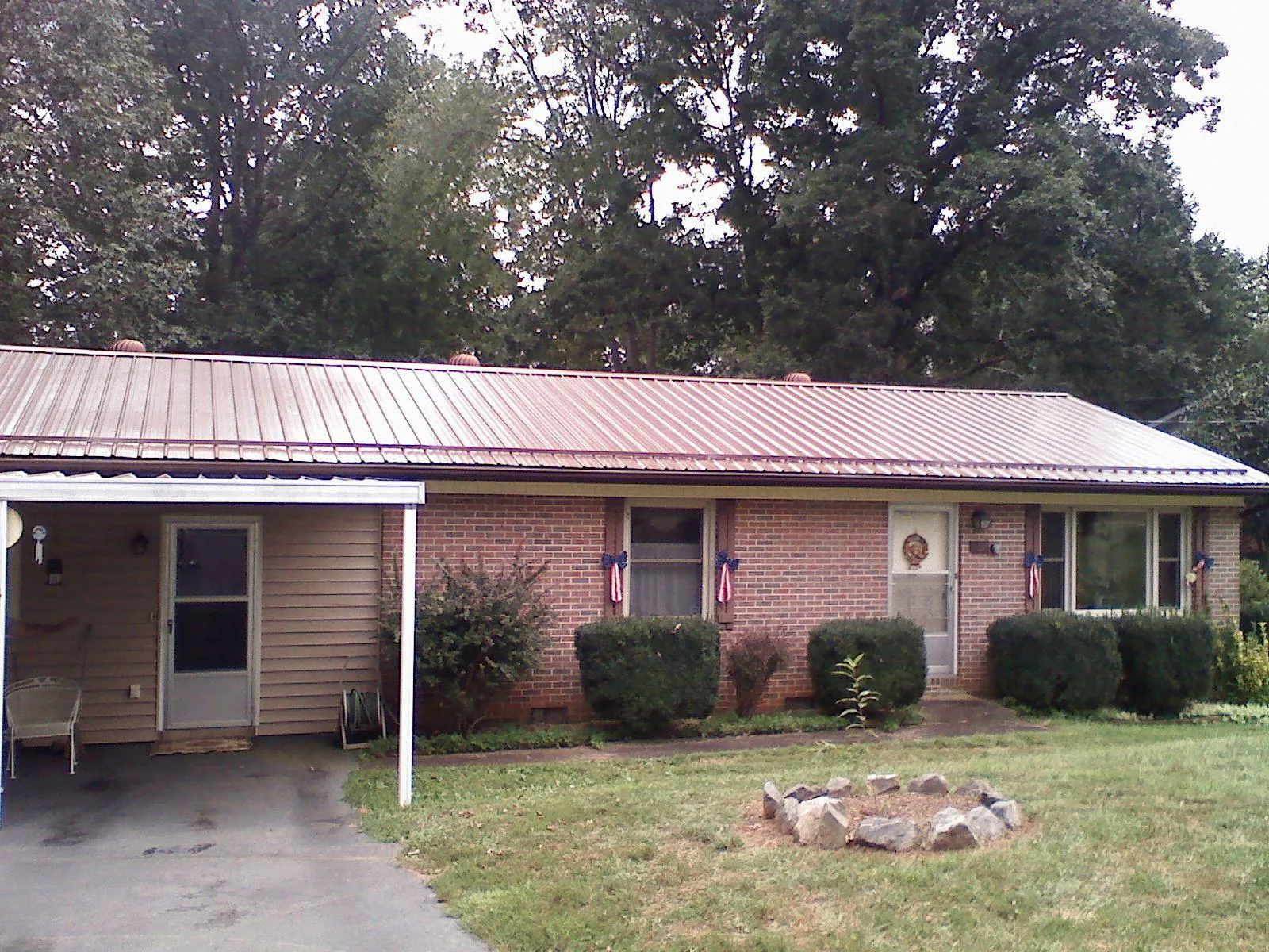 Bronze metal roof and carport on a brick ranch home — Roof Repair work by our crew in Twin Mountain