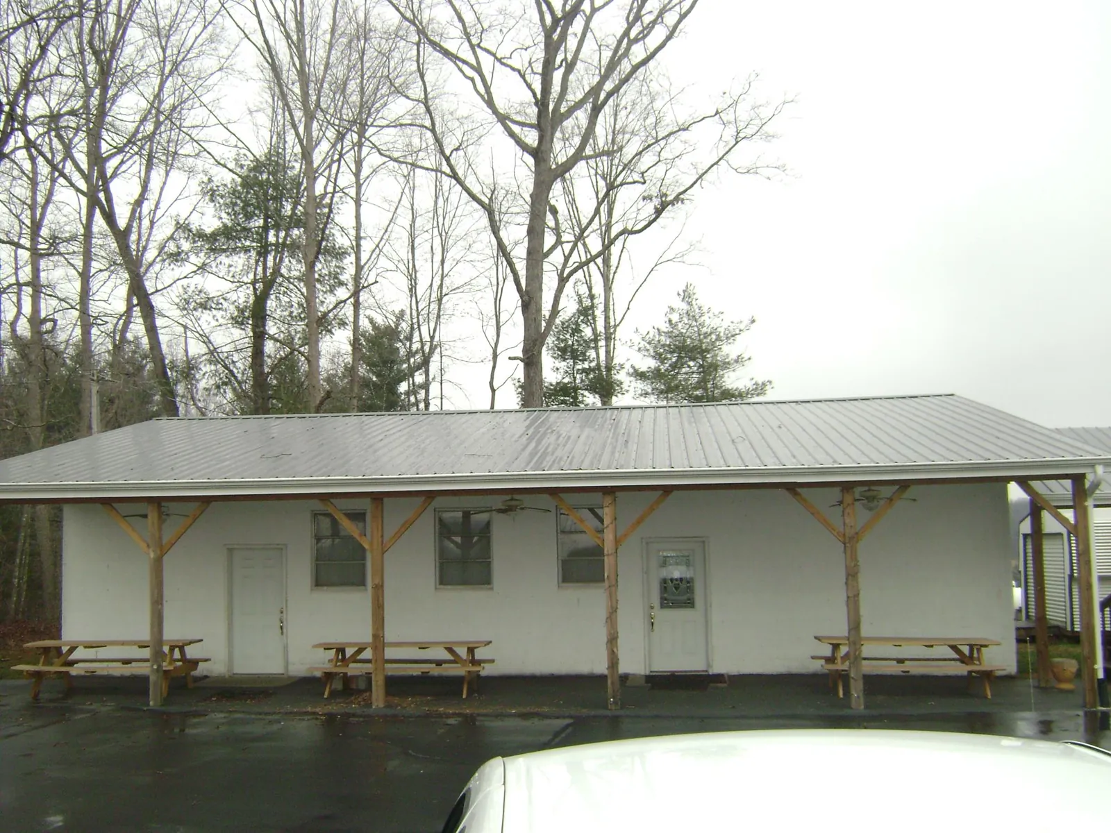 Gray metal roof over a block building with a timber post porch in Twin Mountain